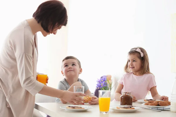 Mutter und Kinder frühstücken zu Hause — Stockfoto