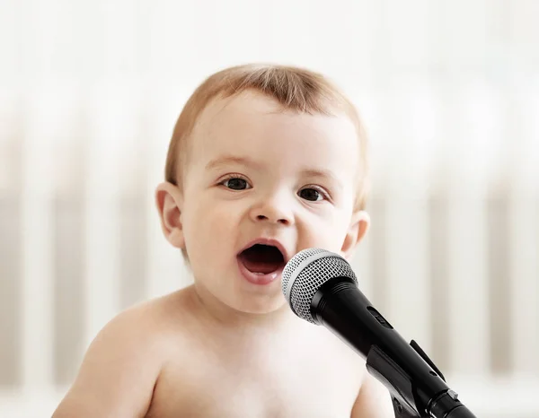 Bébé mignon avec microphone sur fond clair — Photo