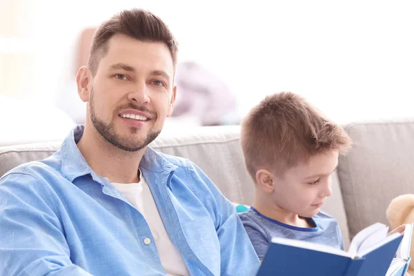Pai e filho lendo livros interessantes — Fotografia de Stock