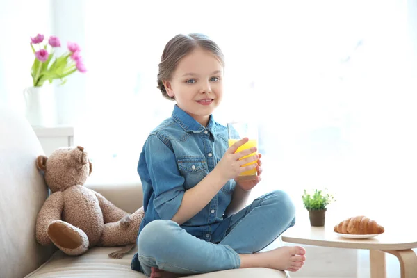 Gadis kecil yang lucu dengan segelas jus di rumah — Stok Foto