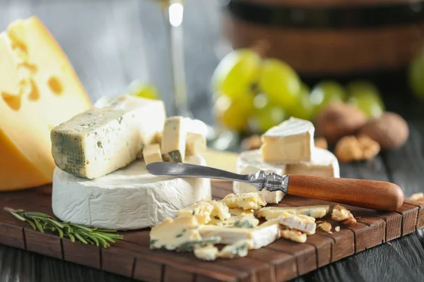 Placa de madeira com queijo — Fotografia de Stock