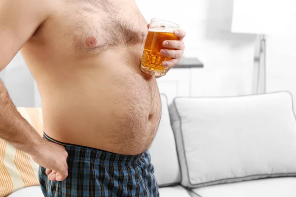 Homem segurando cerveja na barriga grande — Fotografia de Stock