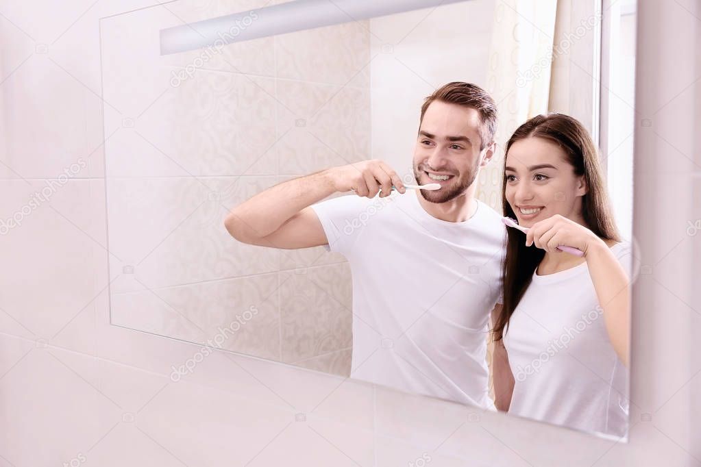 happy couple brushing teeth 