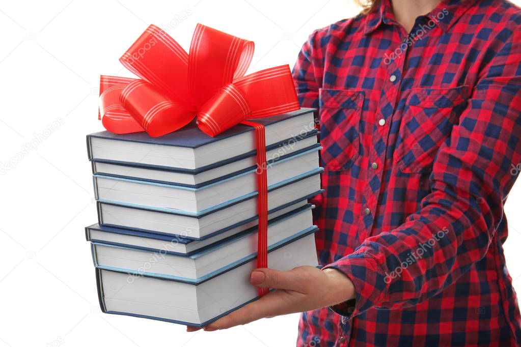 Woman holding stack of books with ribbon 