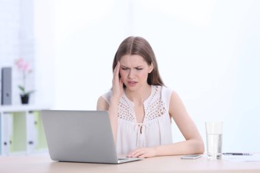 Baş ağrısı çeken genç bir kadın. 