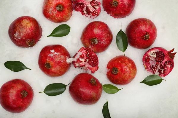 Ripe pomegranates on snow — Stock Photo, Image