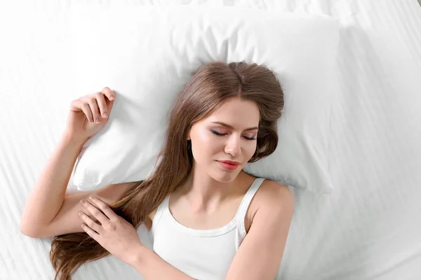 Mujer acostada en la cama con almohada ortopédica — Foto de Stock