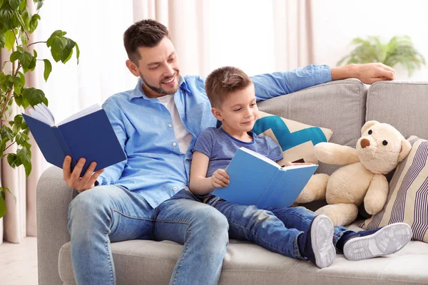 Pai e filho lendo livros interessantes — Fotografia de Stock