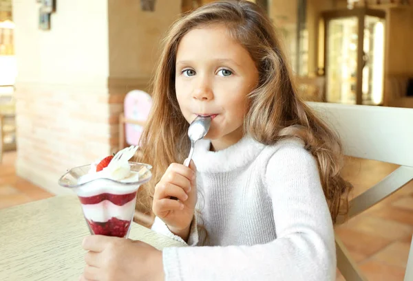 Funny little girl eating ice-cream in cafe — Stock Photo, Image
