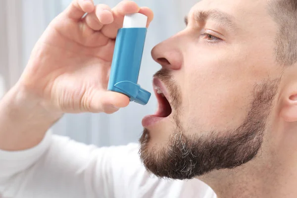 Hombre joven usando inhalador de asma — Foto de Stock