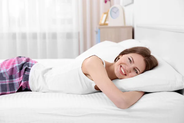 Woman lying on bed with orthopedic pillow — Stock Photo, Image