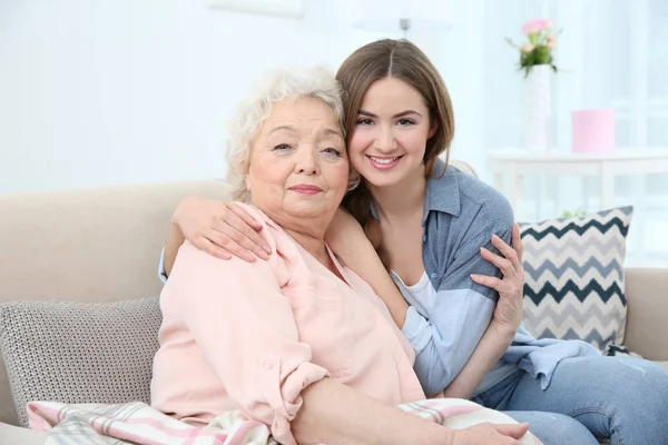 Hermosa chica con la abuela en el sofá en casa —  Fotos de Stock