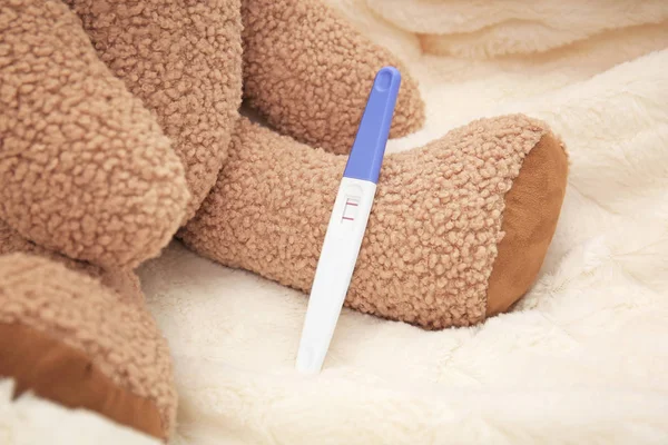 Zwangerschapstest en teddy bear — Stockfoto