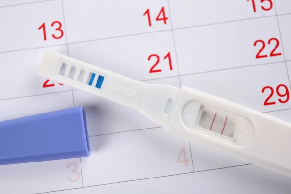 Pregnancy test on calendar — Stock Photo, Image