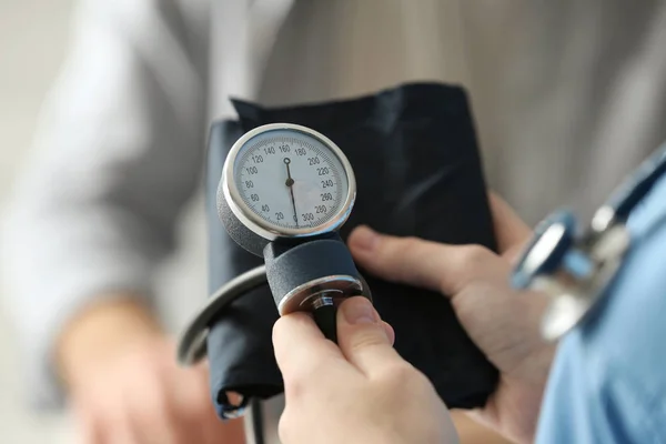 Assistente medico misura la pressione sanguigna del paziente — Foto Stock