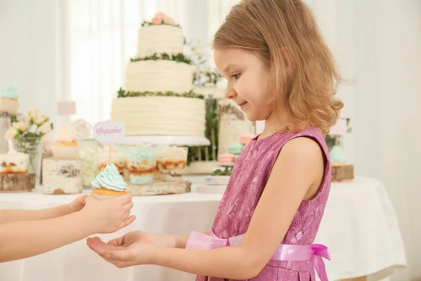 Flickan ger cupcake till vän — Stockfoto