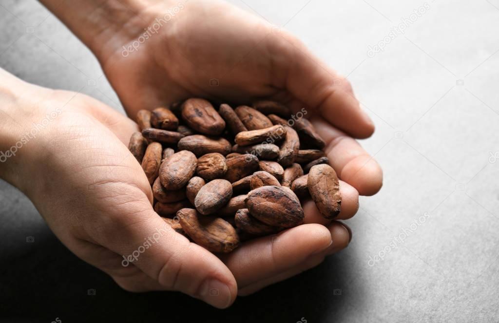 Female hands holding aromatic cocoa beans 