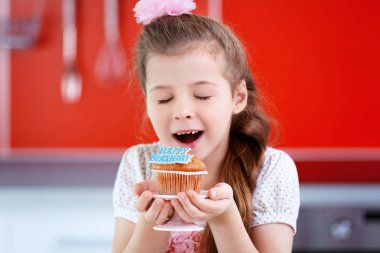 Doğum günü pastası üzerinde arka plan bulanık ile sevimli küçük kız