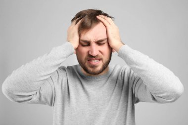 Genç adam baş ağrısı çekiyor.  