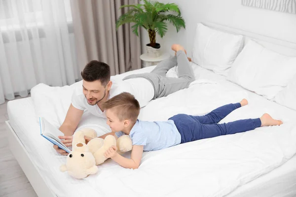 Papá e hijo leyendo interesante libro —  Fotos de Stock