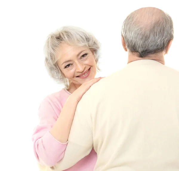 Mulher sênior feliz abraçando seu marido no fundo branco — Fotografia de Stock