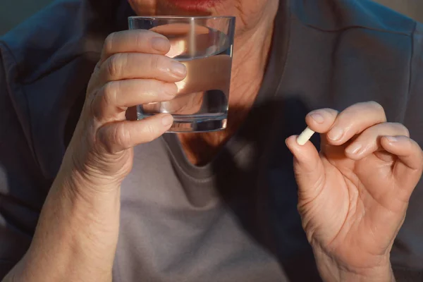 Пожилая женщина принимает таблетки — стоковое фото