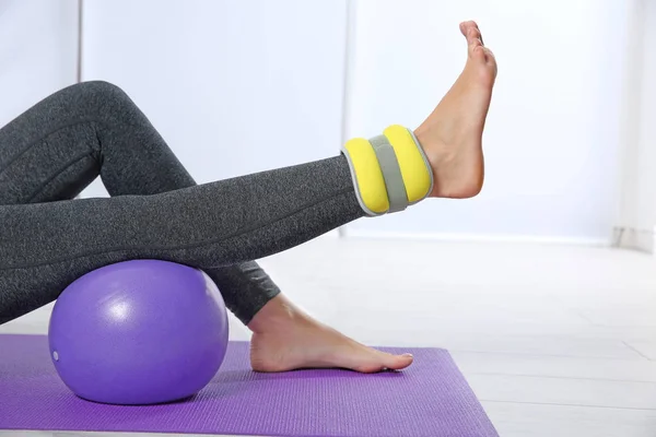 Femme d'entraînement avec poids sur la jambe dans la salle de gym — Photo