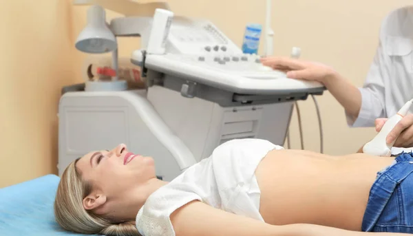 Junge Frau unterzieht sich in moderner Klinik einer Ultraschalluntersuchung — Stockfoto