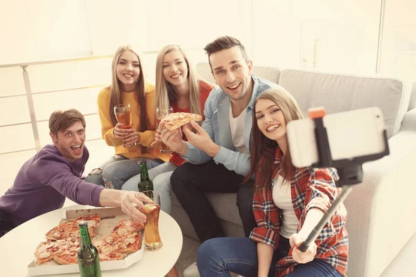 Amigos tomando selfie enquanto comem pizza na festa em casa — Fotografia de Stock