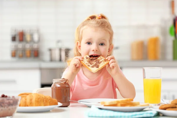 Cute little girl having breakfast at home — Stock Photo, Image