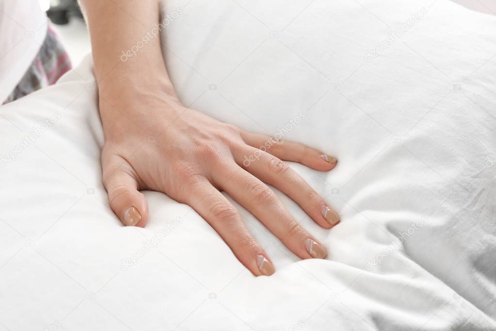 Female hand on orthopedic pillow