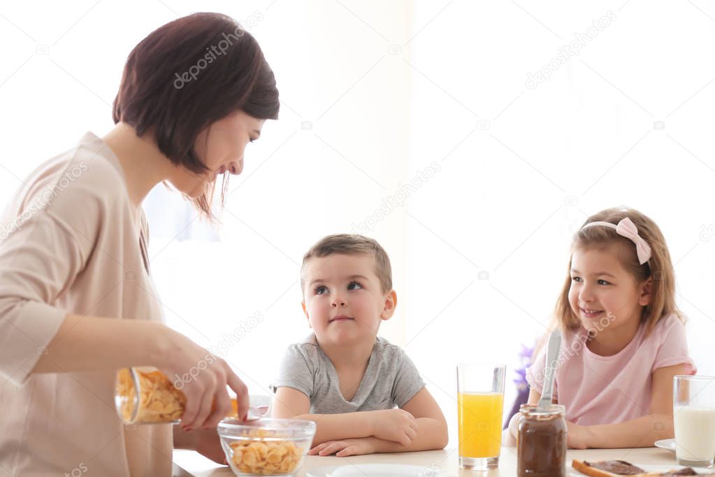 Mother and children having breakfast at home