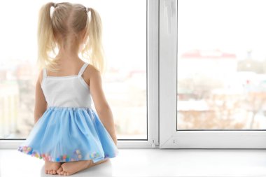 girl sitting on windowsill