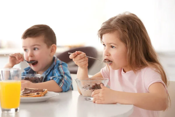 Cute little children having breakfast at home — Stock Photo, Image