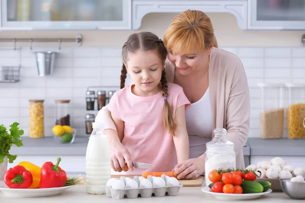 Little girl and her grandmother cooking in kitchen — Stock Photo, Image