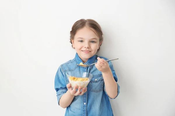 Χαριτωμένο μικρό κορίτσι τρώει κορν φλέικς σε λευκό φόντο — Φωτογραφία Αρχείου