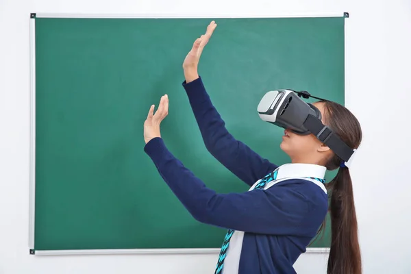 Colegiala con gafas de realidad virtual en el aula —  Fotos de Stock