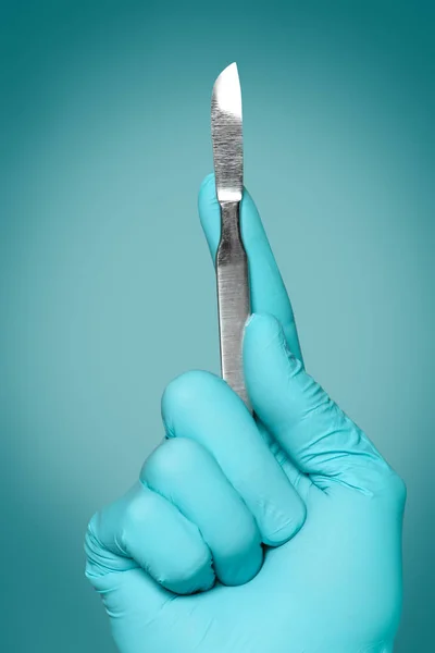 Chirurgo tenendo lancetta su sfondo di colore — Foto Stock