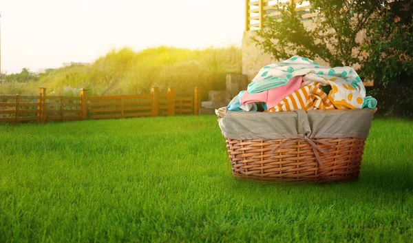Wicker basket with baby laundry — Stock Photo, Image