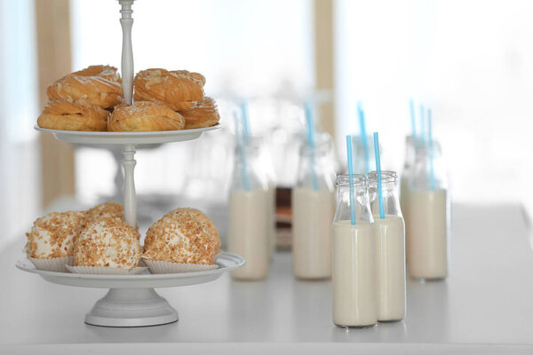 Table with bottles of milk and dessert stand