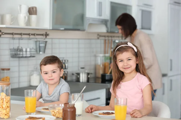Милые маленькие дети завтракают дома — стоковое фото