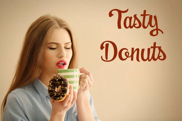 Mujer con sabroso donut y taza de té —  Fotos de Stock