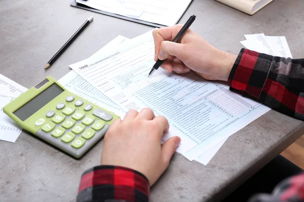 Man aan het werk met documenten en calculator — Stockfoto