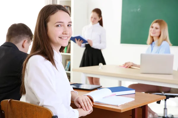 Cute schoolgirl at lesson in classroom — Stock Photo, Image
