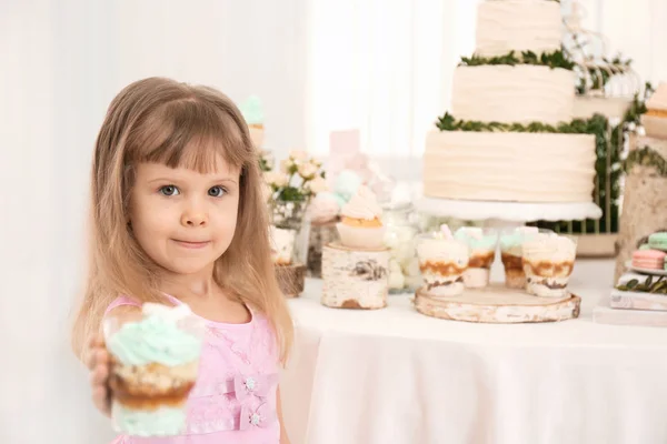 Милая девушка с десертом возле стола подается на вечеринку — стоковое фото