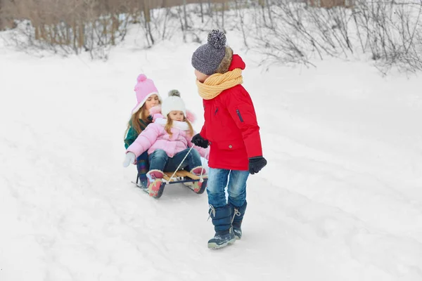 Szczęśliwe dzieci, zabawy i tor saneczkowy na śniegu — Zdjęcie stockowe