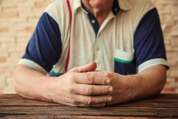 Homem idoso sentado à mesa — Fotografia de Stock