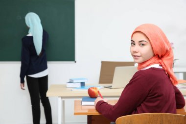 Sevimli kız okul sınıf masada oturan