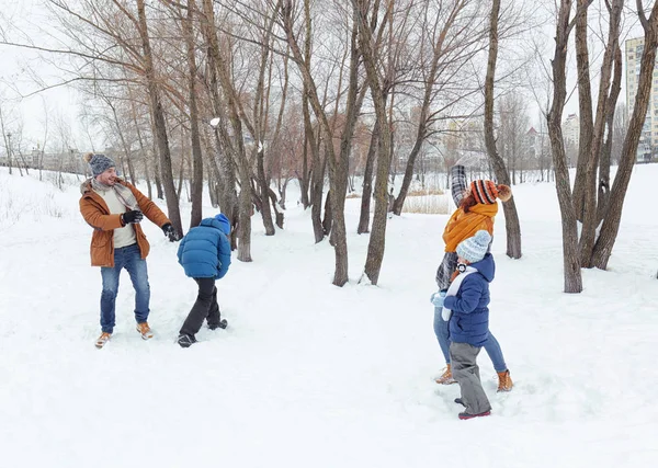Glückliche Familie spielt Schneeballschlacht im Park — Stockfoto