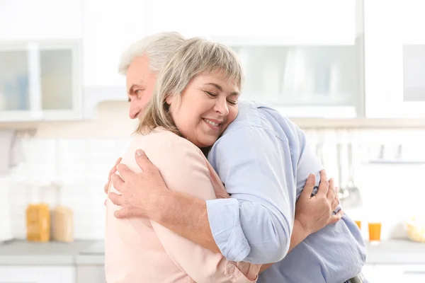 Mellersta åldern par embracing Kitchen — Stockfoto